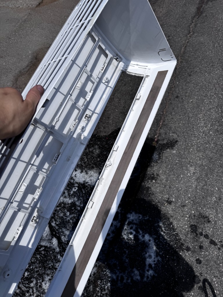 Clean white mini split housing cover after professional washing